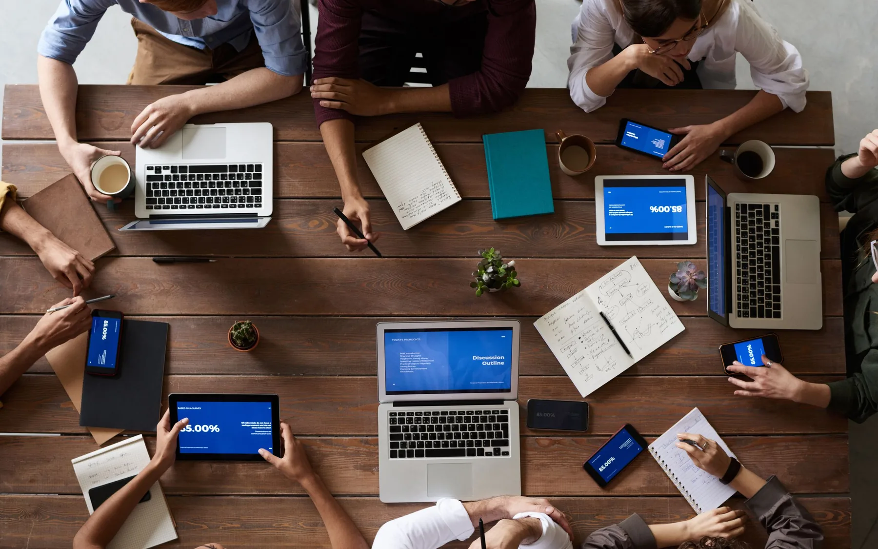 People comparing business notes and research around a table